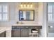 Well lit bathroom features a gray vanity with marble countertop, decorative lighting, and a bathtub at 11533 Bent Oaks St, Parker, CO 80138