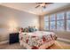 Cozy bedroom with a floral bedspread, ceiling fan, and view of the window at 11533 Bent Oaks St, Parker, CO 80138