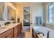 Bathroom featuring double sinks, granite countertops, a tub, and tiled floors at 3325 Yale Dr, Broomfield, CO 80023