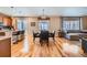 Open-concept dining area with hardwood floors, a round wooden table, and seamlessly connected to the kitchen and living room at 3325 Yale Dr, Broomfield, CO 80023