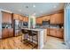 Well-lit kitchen with stainless steel appliances, a center island with bar seating, and wooden cabinetry at 3325 Yale Dr, Broomfield, CO 80023