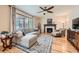 Comfortable living room with a fireplace, large window, hardwood flooring, and stylish decor at 3325 Yale Dr, Broomfield, CO 80023