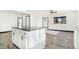 Bright kitchen with white cabinets, island, and gray flooring at 655 S Osceola St, Denver, CO 80219