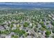 Expansive aerial view of a neighborhood, lush trees, and a home featuring solar panels on the roof at 10142 Mountain Maple Dr, Highlands Ranch, CO 80129