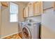 Well-equipped laundry room with modern washer and dryer and overhead cabinets at 10142 Mountain Maple Dr, Highlands Ranch, CO 80129