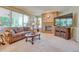 Cozy living room with a brick fireplace, large windows offering natural light, and comfortable seating at 10142 Mountain Maple Dr, Highlands Ranch, CO 80129