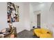 Bright hallway with gray carpet, modern art, yellow chair, and a well-lit desk at 14129 E Dickinson Dr # D, Aurora, CO 80014