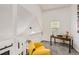 Cozy loft area with a bright yellow arm chair, desk, and lots of light from the windows at 14129 E Dickinson Dr # D, Aurora, CO 80014