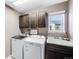 Laundry room with dark brown cabinets, washer, dryer and a utility sink at 2633 Garganey Dr, Castle Rock, CO 80104