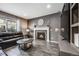 Living room with fireplace, leather sofa, and large clock at 2633 Garganey Dr, Castle Rock, CO 80104