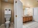 Bathroom featuring a toilet, storage cabinet, and vanity with double sinks at 5175 Quari St, Denver, CO 80239