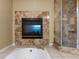 Elegant bathroom with fireplace and luxurious soaking tub, accented with a tiled shower at 5175 Quari St, Denver, CO 80239