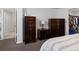 Bedroom featuring dark wood furniture, neutral walls, carpet and contemporary furnishings and decor at 5175 Quari St, Denver, CO 80239