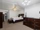 Bright bedroom with ceiling fan, featuring neutral walls, carpet and contemporary furnishings and dark wood furniture at 5175 Quari St, Denver, CO 80239