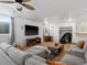 Spacious living room featuring a gray sectional sofa, wood-look flooring, and large television at 5175 Quari St, Denver, CO 80239