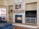 Cozy living room with a stone fireplace, built-in shelves, and a mounted television for entertainment at 5175 Quari St, Denver, CO 80239