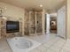 Elegant bathroom features a jetted tub, shower, and fireplace at 5175 Quari St, Denver, CO 80239