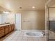 Bright main bathroom features a soaking tub, tiled floors, and a large walk-in shower at 5175 Quari St, Denver, CO 80239