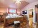 Main bedroom features wood floors, ceiling fan, and decorative bedding with a view into the bathroom at 5175 Quari St, Denver, CO 80239