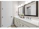 Elegant bathroom with double sinks, sleek white cabinetry, modern fixtures, and decorative mirrors at 5707 Cadara Way, Parker, CO 80134