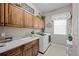 Functional laundry room boasts wooden cabinets, ample counter space, sink and a modern washer-dryer at 5707 Cadara Way, Parker, CO 80134