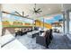 Covered outdoor patio with stylish furnishings, fire pit, and scenic backyard views at 5707 Cadara Way, Parker, CO 80134