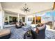Inviting covered patio with a fire pit, comfortable seating, and stylish ceiling fan at 5707 Cadara Way, Parker, CO 80134