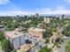 Aerial view of the apartment complex, showcasing lush landscaping and the surrounding cityscape and skyline at 1350 Josephine St # 502, Denver, CO 80206