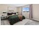 Cozy bedroom with neutral colors, large window offering natural light, and comfortable furnishings at 1350 Josephine St # 502, Denver, CO 80206
