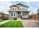Two-story gray house with white trim, front porch, and landscaped lawn at 16911 Buffalo Valley Path, Monument, CO 80132
