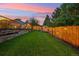 Beautiful fenced backyard featuring a grassy lawn, garden shed, and lush trees at 18601 E Louisiana Ave, Aurora, CO 80017