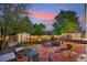Inviting backyard featuring a brick patio with fire pit, shed, and seating area at 18601 E Louisiana Ave, Aurora, CO 80017