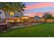 Serene backyard showcasing a spacious lawn, deck, and decorative retaining wall, ideal for relaxation and gatherings at 18601 E Louisiana Ave, Aurora, CO 80017