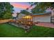 Backyard featuring a stone retaining wall with flowers, patio with fire pit at 18601 E Louisiana Ave, Aurora, CO 80017