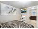 Bedroom in basement with artwork and television; part of a sofa is also visible at 18601 E Louisiana Ave, Aurora, CO 80017