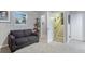 Cozy living room with a gray couch, carpeted floors, and natural light from a window at 18601 E Louisiana Ave, Aurora, CO 80017