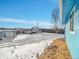 Snowy backyard with vehicles parked and a house at 329 Lilac Dr, Lochbuie, CO 80603