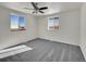 Well-lit bedroom with grey carpet and two large windows at 329 Lilac Dr, Lochbuie, CO 80603