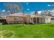 Rear view of the brick ranch house showing covered patio and manicured lawn at 1077 Salem St, Aurora, CO 80011