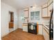 Bright kitchen showcasing wooden trimmed cabinets, black appliances, and vinyl floors at 1077 Salem St, Aurora, CO 80011