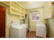 Well-lit laundry room with white appliances, storage shelves, and wood-look flooring at 1077 Salem St, Aurora, CO 80011