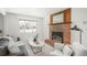 Cozy living room with a brick fireplace, neutral decor, and a large window offering plenty of natural light at 1077 Salem St, Aurora, CO 80011