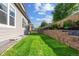 Green backyard with a retaining wall and manicured landscaping on a sunny day at 10929 Endeavor Dr, Parker, CO 80134
