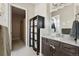 Bathroom featuring a vanity with granite countertop, storage cabinet, and decorative mirror at 10929 Endeavor Dr, Parker, CO 80134
