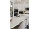 Bright kitchen featuring white cabinets, granite countertops, stainless steel appliances, and breakfast bar seating at 10929 Endeavor Dr, Parker, CO 80134