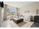 Well-lit living room with neutral tones, hardwood floors, large windows, and a comfortable seating area at 10929 Endeavor Dr, Parker, CO 80134