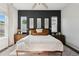 Well-lit main bedroom featuring a dark accent wall, ceiling fan, and plush bedding at 10929 Endeavor Dr, Parker, CO 80134