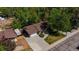 Aerial view of a brick home with an attached garage and lush green trees surrounding the property at 12771 W 6Th Pl, Lakewood, CO 80401
