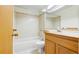 Well-lit bathroom boasts a single sink vanity, tub/shower combination and earth toned tile at 12771 W 6Th Pl, Lakewood, CO 80401