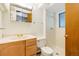 Bathroom features a single sink vanity, mirror, and tiled tub/shower combination with a glass enclosure at 12771 W 6Th Pl, Lakewood, CO 80401